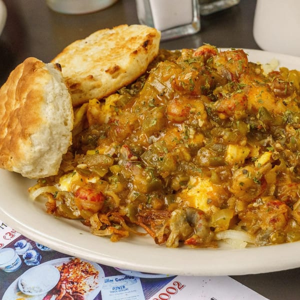 Slim Goodies Diner's crawfish étouffée with two biscuits, served on a white plate.